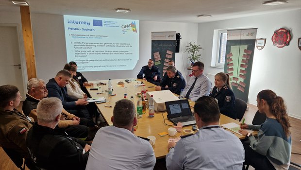 Mehrere Personen sitzen an einem Konferenztisch und besprechen das Projekt CIFAD III.
