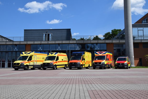 Das Bild zeigt einen Parkplatz mit vier verschiedenen Rettungswagen und einem Notarzt-Fahrzeug