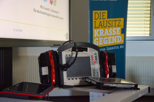 Das Bild zeigt medizinisches Equiment vor dem Hintergrund eines Werbeaufstellers für die Lausitz